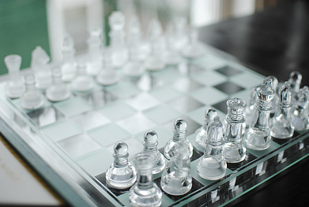 clear glass chess piece on chess board thumbnail