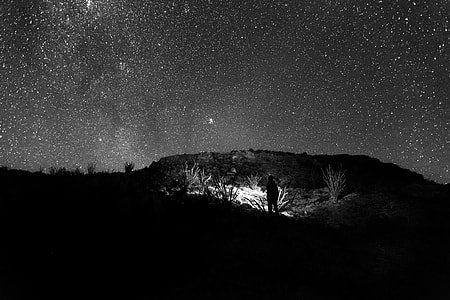 silhouette of person on mountain under starry night thumbnail