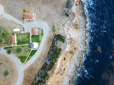 aerial view of building on seashore near body of water thumbnail