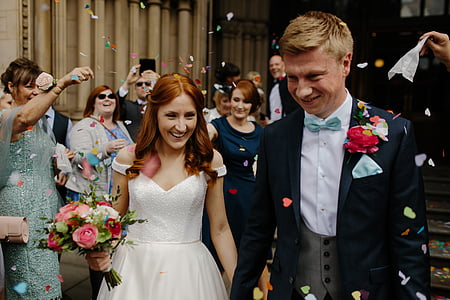 woman and man smiling holding hands surrounded by people throwing confetti thumbnail