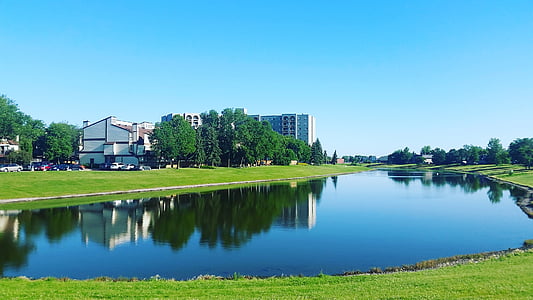 buildings and trees near body of water thumbnail