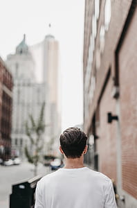 man walking beside brown concrete building thumbnail