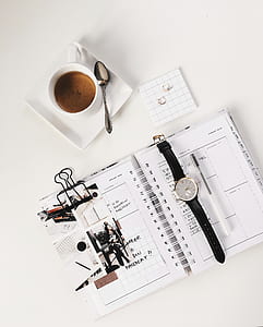 round silver-colored chronograph watch on printed paper thumbnail