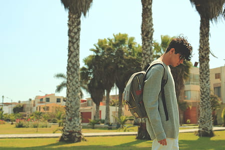 man with backpack standing near trees thumbnail