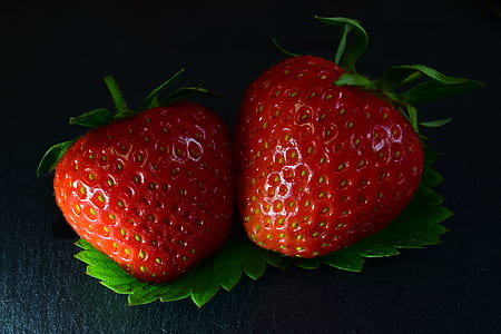 two strawberry fruits on black surface thumbnail