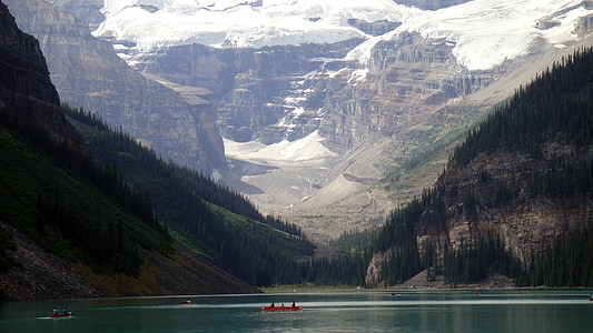 boat on water between snow capped mountains thumbnail