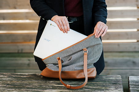 woman putting white Acer Chromebook inside tote bag thumbnail