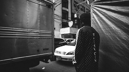 man standing in front of vehicles during daytime thumbnail