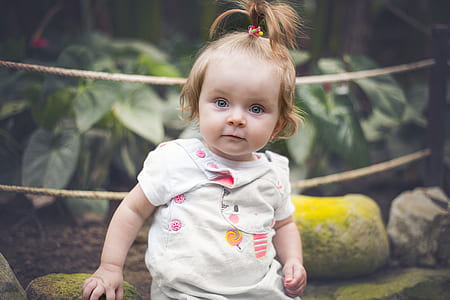 baby holding green ston e thumbnail