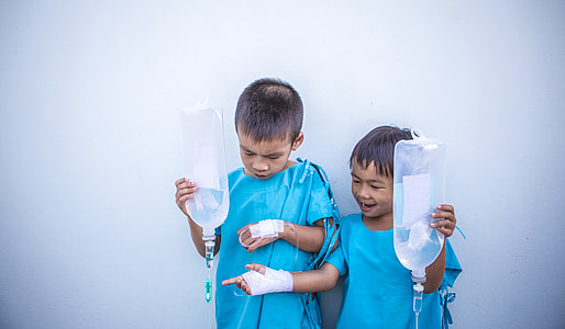 two patient boys holding dextrose bags thumbnail