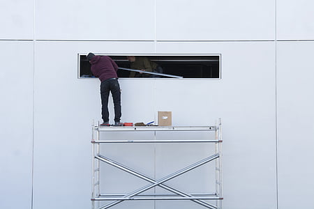 man standing on gray scaffolding thumbnail