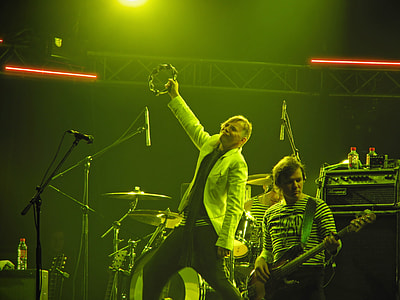 man playing guitar beside man holding tambourine on stage at night thumbnail