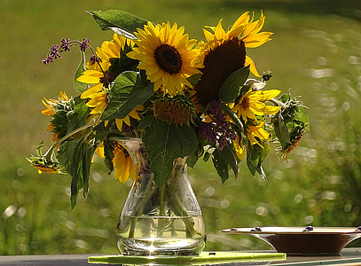sunflowers in glass vase on glass table thumbnail
