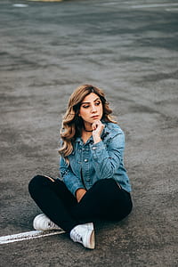 woman in denim jacket sitting on road thumbnail