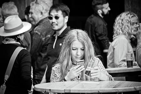 grayscale photo of woman holding iPhone 5s thumbnail