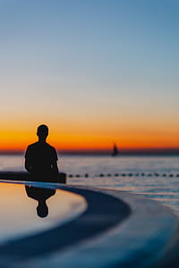 The man is looking at the sunset by the sea thumbnail