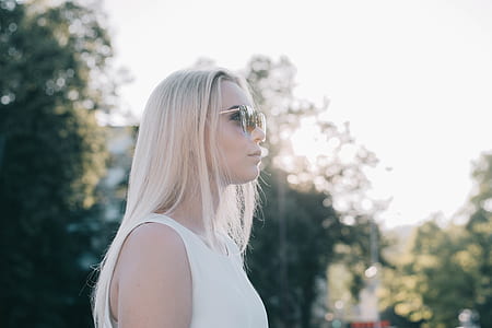 standing woman surrounded by green leaf trees thumbnail