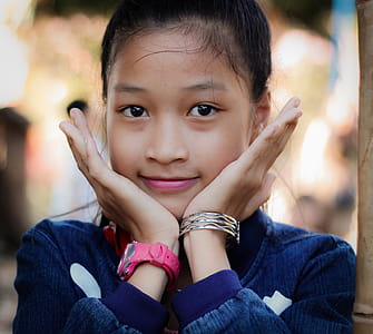 Girl Wearing Blue Long-sleeved Top Resting Face On Hands thumbnail