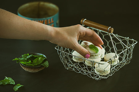 person holding macaroons near basket thumbnail