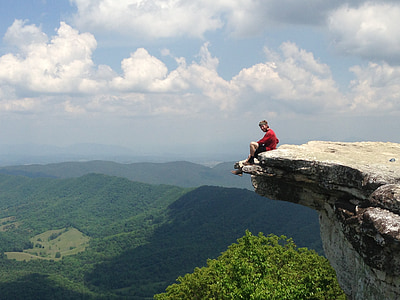 man sitting on ledge of rock thumbnail