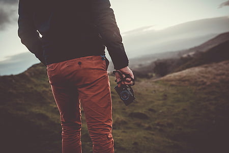 man holding camera standing on grass thumbnail
