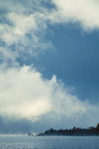 body of water under cloudy sky during day time thumbnail