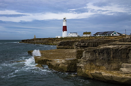 white and red lighthouse near body of water during daytime thumbnail