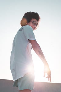 man wearing white t-shirt and gray shorts while standing thumbnail