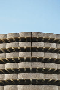 brown concrete building with blue sky background thumbnail