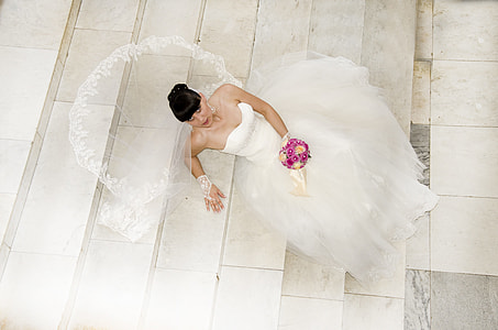 bride seating on chair holding bouquet of flower thumbnail