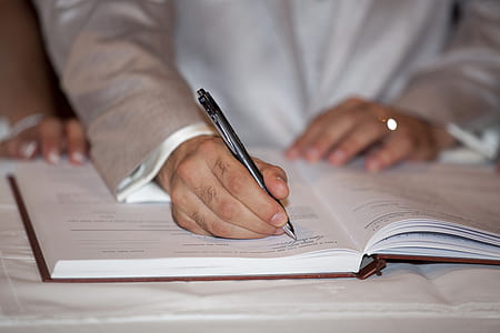 selective focus photography of person writting on book thumbnail