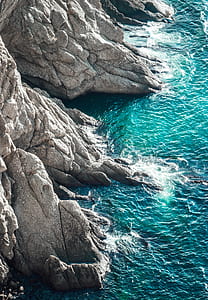 aerial photo body of water splashing on rocks thumbnail