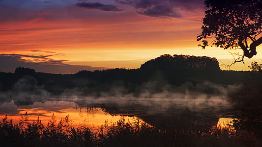 silhouette photo of landscape mountain behind body of water thumbnail