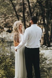 smiling woman wearing white dress standing in front of man thumbnail