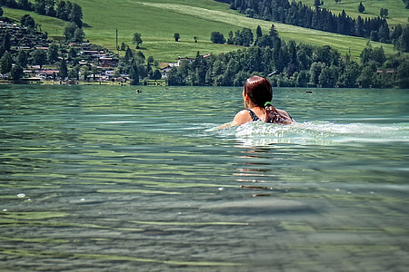 women's swimming near trees thumbnail
