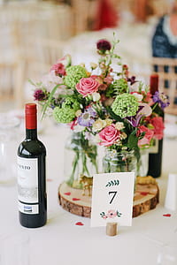wine bottle near bouquet of flower on the table thumbnail