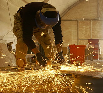 man holding welding rod wearing blue welding helmet thumbnail