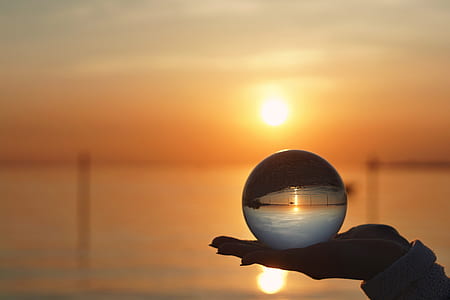 shallow focus photography of person holding crystal ball thumbnail