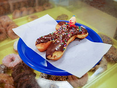 Clown donut sitting on a blue plate in a donut shop. thumbnail