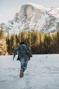 man running on snowfield near mountain alps thumbnail
