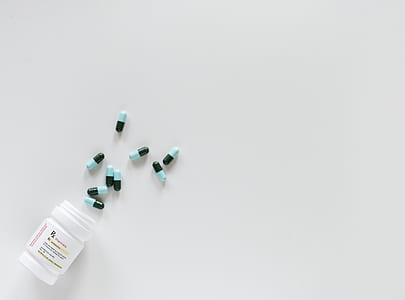 blue-and-black medication pills spilled from bottle thumbnail