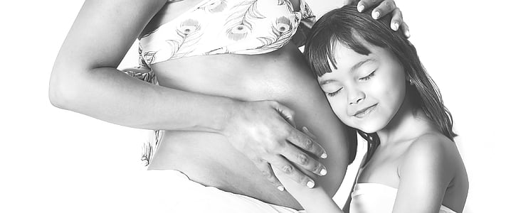 girl in white tube dress holding pregnant woman tummy thumbnail