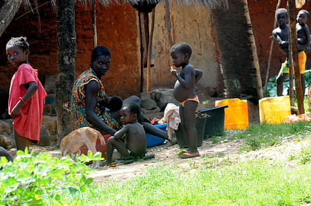photo of three children near woman sitting in front of pail thumbnail