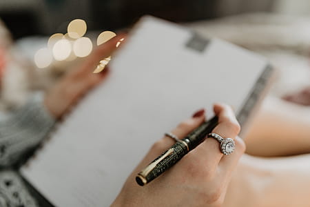Writing in a notebook lying in bed, with coffee, candles, and gingerbreads thumbnail