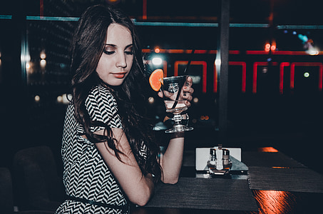 woman sitting on chair while holding a drink thumbnail