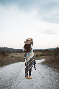 woman standing in road staring at grass field thumbnail
