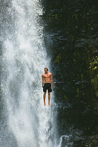 man wearing black shorts in front of waterfalls thumbnail