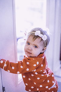 toddler holding on door facing the camera thumbnail
