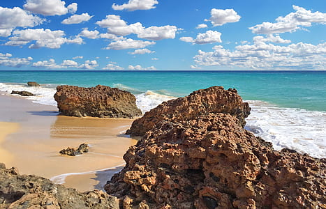 landscape photography of rock formation near sea thumbnail