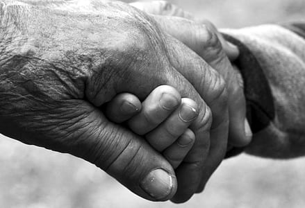 greyscale photo of man and children holding hands thumbnail